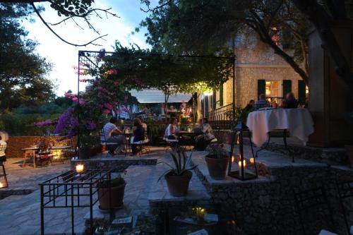 a group of people sitting at a table in a patio at Boutique Hotel Boškinac in Novalja