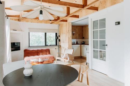 Boshuisje Noi op de Veluwe في Hattemerbroek: غرفة معيشة بها طاولة ومطبخ