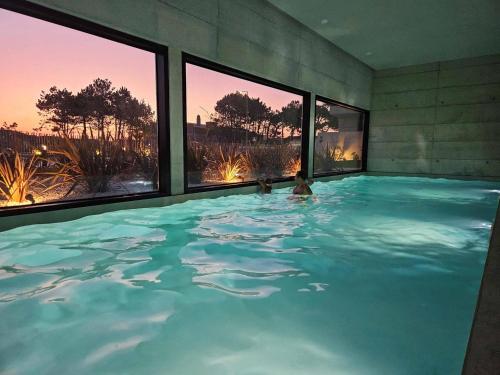a large swimming pool with two people in it at GuestReady - Seaside oasis in private condo in Apúlia