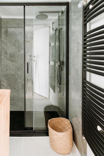 a bathroom with a glass shower and a stool at Boshuisje Noi op de Veluwe in Hattemerbroek