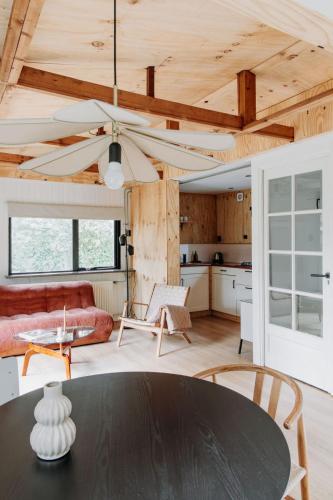 a living room with a table and a kitchen at Boshuisje Noi op de Veluwe in Hattemerbroek