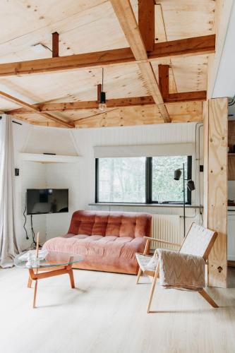 a living room with a couch and a table at Boshuisje Noi op de Veluwe in Hattemerbroek