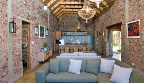 a living room with a couch and a kitchen at Winelands Manor Vineyard Views in Riebeek-Kasteel