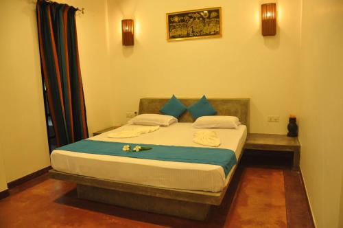 a bedroom with a large bed with blue pillows at Green Villa Unawatuna in Unawatuna