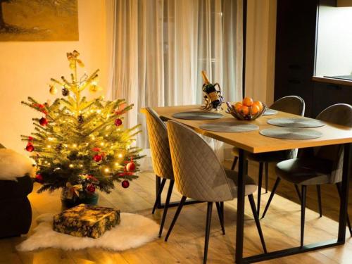 a dining room with a christmas tree and a table at Miracle Seasons in Liptovský Mikuláš