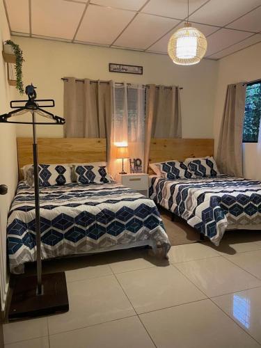 Un dormitorio con dos camas y una lámpara. en Casa 911, en San Salvador