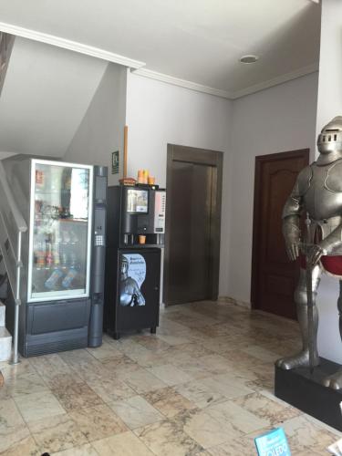 a room with a refrigerator and a statue in it at Hotel Godofredo in Toledo