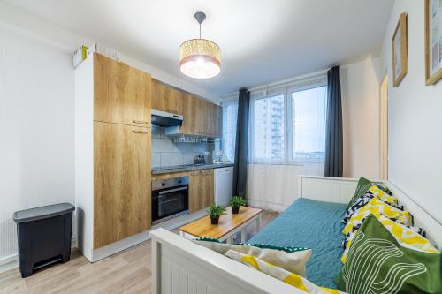 ein kleines Apartment mit einem Sofa und einer Küche in der Unterkunft The Paris 9th Sky - 8min to Paris in Saint-Denis