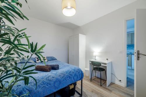 ein Schlafzimmer mit einem Bett, einem Schreibtisch und einer Pflanze in der Unterkunft The Paris 9th Sky - 8min to Paris in Saint-Denis