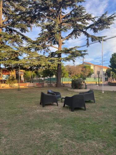 un grupo de bancos en un parque con un árbol en Hotel Santa Bárbara, en La Falda