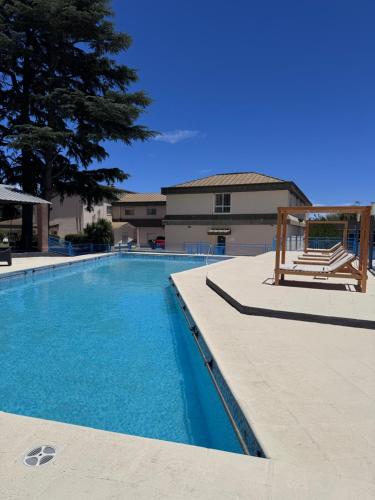 Una gran piscina en un edificio con un árbol. en Hotel Santa Bárbara, en La Falda