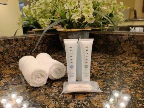 Coastal Breeze Luxurious Coastal Villa Steps to Cinnamon Beach Beautiful Pools! Perfect for Families في Hawthorne: فرشاة أسنان ومنشفتين على طاولة في الحمام