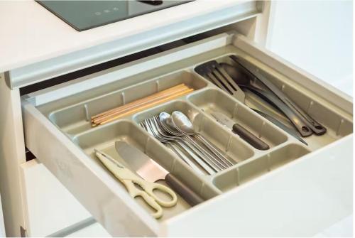 a drawer in a cabinet filled with utensils at Stylish Luxury 1 Bedroom, Hyde Sukhumvit 11, Near BTS Nana & Asok in Bangkok
