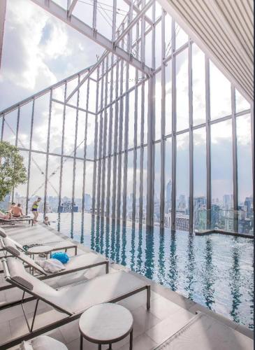 a swimming pool in a building with a view of the city at Stylish Luxury 1 Bedroom, Hyde Sukhumvit 11, Near BTS Nana & Asok in Bangkok