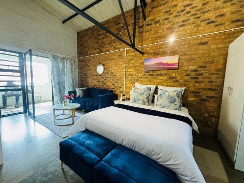ein Schlafzimmer mit einem großen Bett und einer Ziegelwand in der Unterkunft Blue Haven on Craftmanship Hotel with WiFi Pool & Parking in Johannesburg