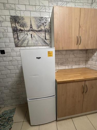 a refrigerator in a kitchen with a picture on the wall at London Budget-Friendly Stay in London