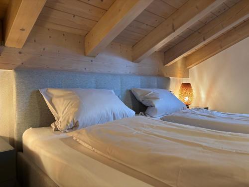 2 bedden in een kamer met houten plafonds bij Chesa Piz mit privater Sauna in Pfronten