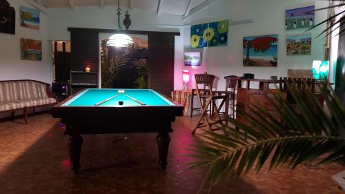 mesa de ping pong en una habitación con mesa de billar en Villa Patio Colibri, en Chambort