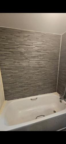 a white bath tub in a room with a wall at Special in Waltham Cross