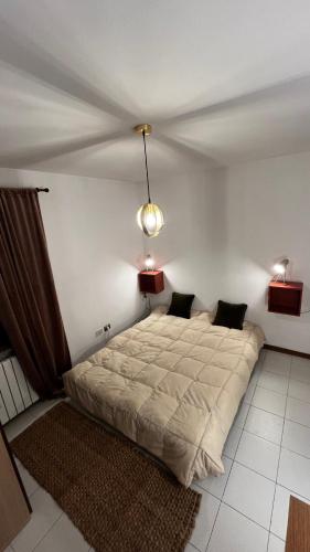 a bedroom with a bed and two lights on the wall at Appartamento Catalina in Saint-Pierre