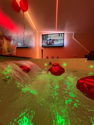 a room with a pool of water with red and green lights at Elite Suite in Castellana Grotte