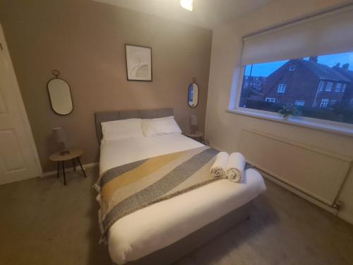a bedroom with a large bed with a window at Marsden Modern 3 Bed in South Shields