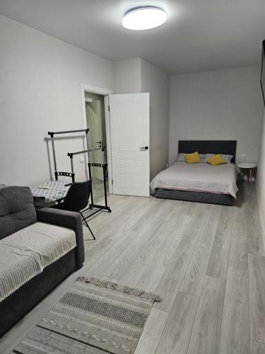 a living room with a bed and a couch at Сучасна квартира в новобудові біля луцького кільця in Rivne