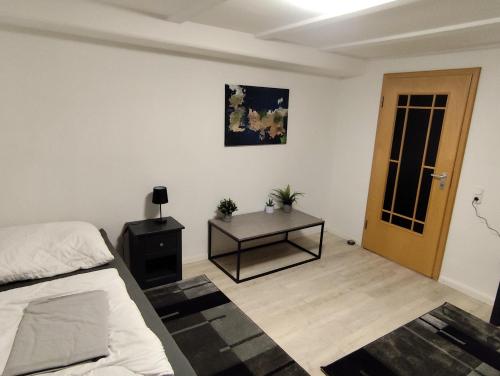 a bedroom with a bed and a table and a door at FeWo Hospitalskapelle in Schwalmstadt