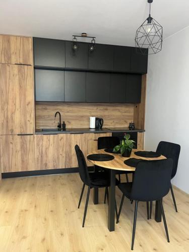 a kitchen and dining room with a table and chairs at Słoneczny Apartament Karpicko in Karpicko