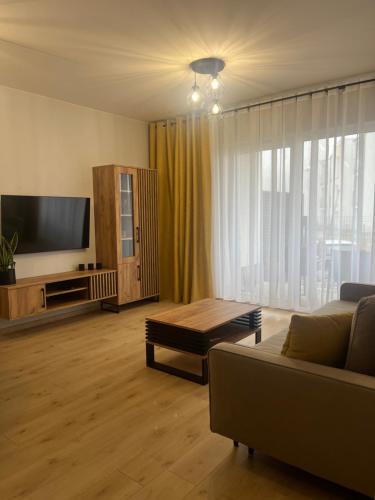 a living room with a couch and a flat screen tv at Słoneczny Apartament Karpicko in Karpicko