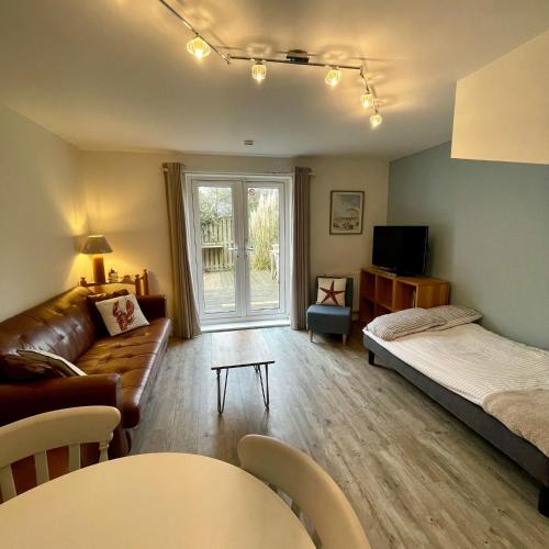 a living room with a couch and a bed at Rock Lobster in Camber