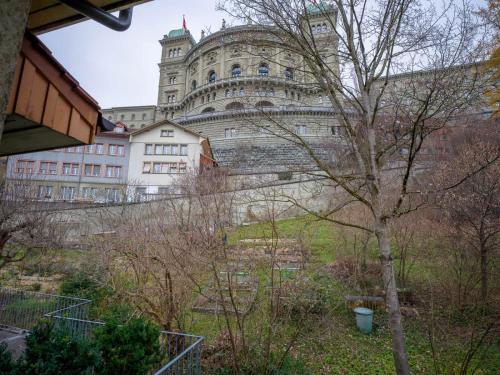 a large building with a tree in front of it at Central Bern Flat - Balcony & Bundeshaus View in Bern