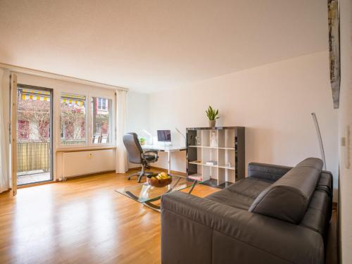 a living room with a couch and a desk at Central Bern Flat - Balcony & Bundeshaus View in Bern