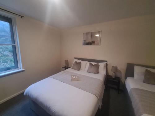 ein Schlafzimmer mit zwei Betten und einem Fenster in der Unterkunft Quayside Apartment in Newcastle upon Tyne