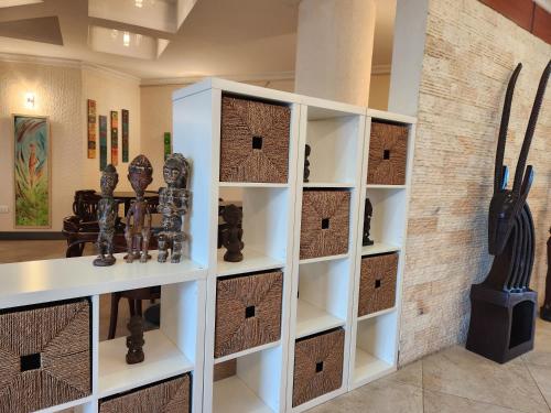 a room with a wall of shelves with artifacts at Kora Hotel Suites in Addis Ababa