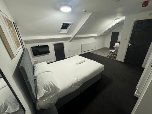 Un dormitorio con una gran cama blanca en una habitación. en Park Studios, en Sunderland