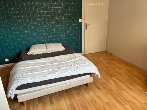 Un dormitorio con una cama con una pared verde. en Green room - Wifi - Centre ville - Cosy, en Annemasse