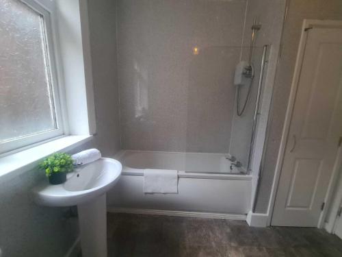 een badkamer met een bad, een wastafel en een douche bij Pudding Chare Apartments in Newcastle upon Tyne