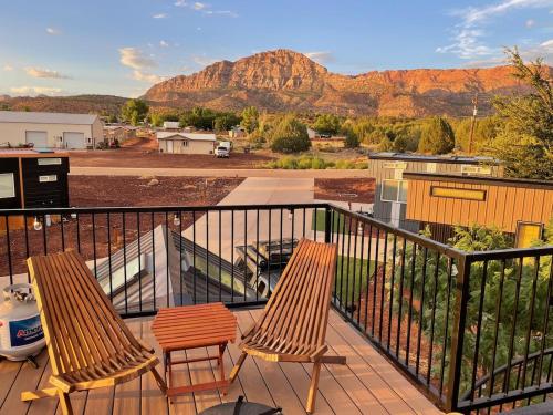 a balcony with two chairs and a view of a mountain at Zion Tiny Home Rooftop View Deck & Hot Tub in Apple Valley