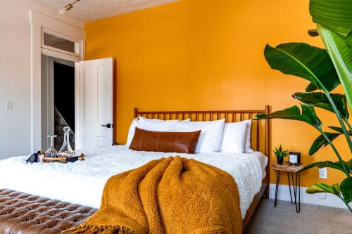 a bedroom with a bed with an orange wall at Short North Convention King Bed Free Parking! in Columbus