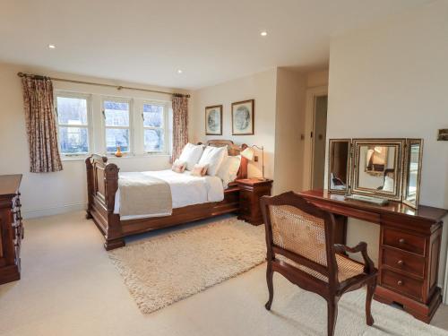a bedroom with a bed and a desk and a mirror at Orchard House in Leyburn