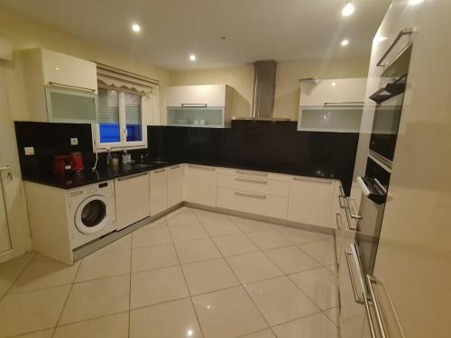 una cocina blanca con una lavadora dentro en Large house near Mérignac Airport, en Mérignac
