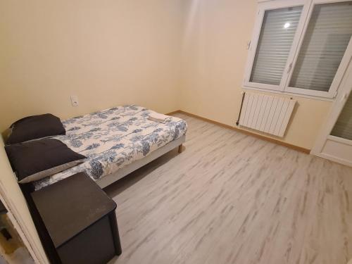 Un dormitorio pequeño con una cama y una ventana. en Large house near Mérignac Airport, en Mérignac