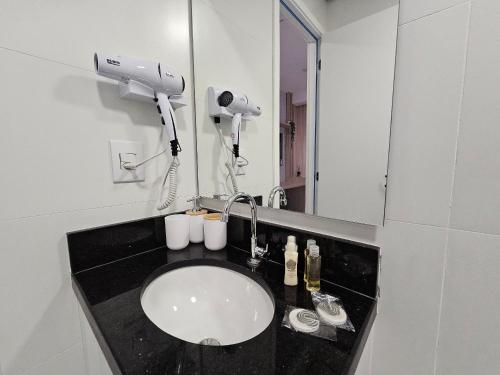 a bathroom with a sink and a mirror at Apartamento com Piscina no Rooftop in São Paulo