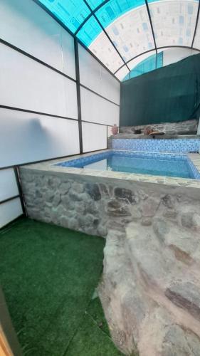 a large swimming pool in a building with a ceiling at Casa Corazao in Urubamba