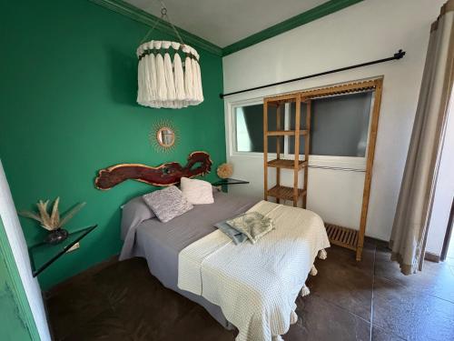 a bedroom with green walls and a bed in it at Boho luz terrace in San Miguel de Allende