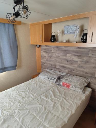a bedroom with a bed and a wooden wall at Veni Mobilház in Privlaka