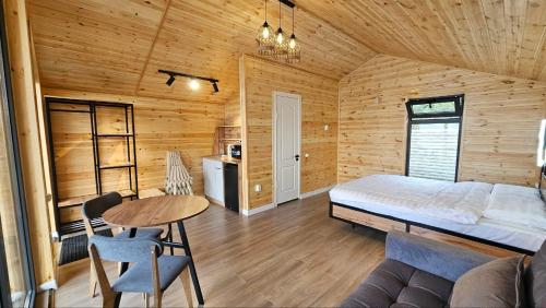 a bedroom with a bed and a table in a room at Aiwa Eco Hotel in Karakol