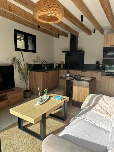 un soggiorno con tavolino e una cucina di Le refuge de César a Pouzac