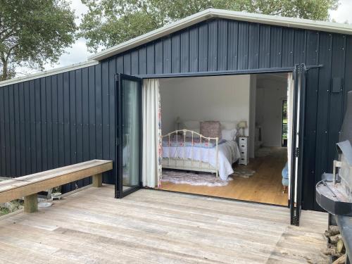 a black shed with a bed inside of it at The woolshed - Oruanui in Oruanui